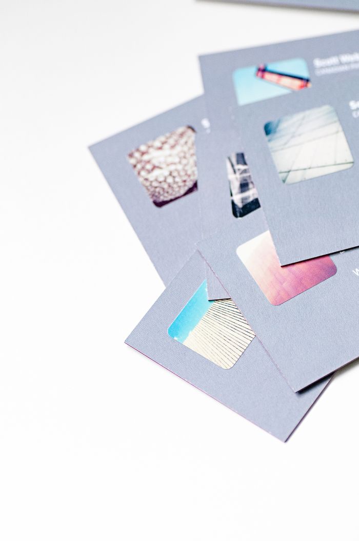 Vue en plongée de cartes de visite au design abstrait avec découpes sur fond blanc.